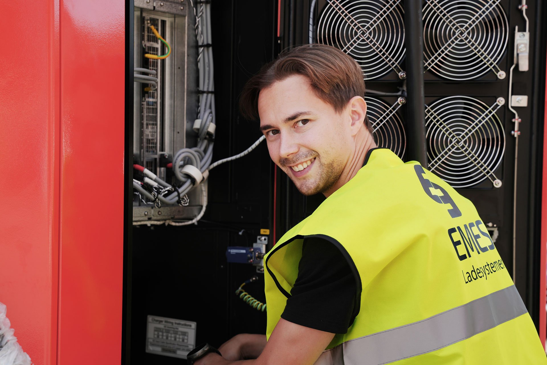 Erik i EMES smiler foran åpen DC-lader